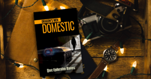 Book cover for Dragon's Men: Domestic by author Doc Ephraim Bates. Book cover (showing a casket overlaid with nuclear countdown timer) is sitting on a wooden desktop strewn with a camera, suede wallet, leather-banded analog watch,.